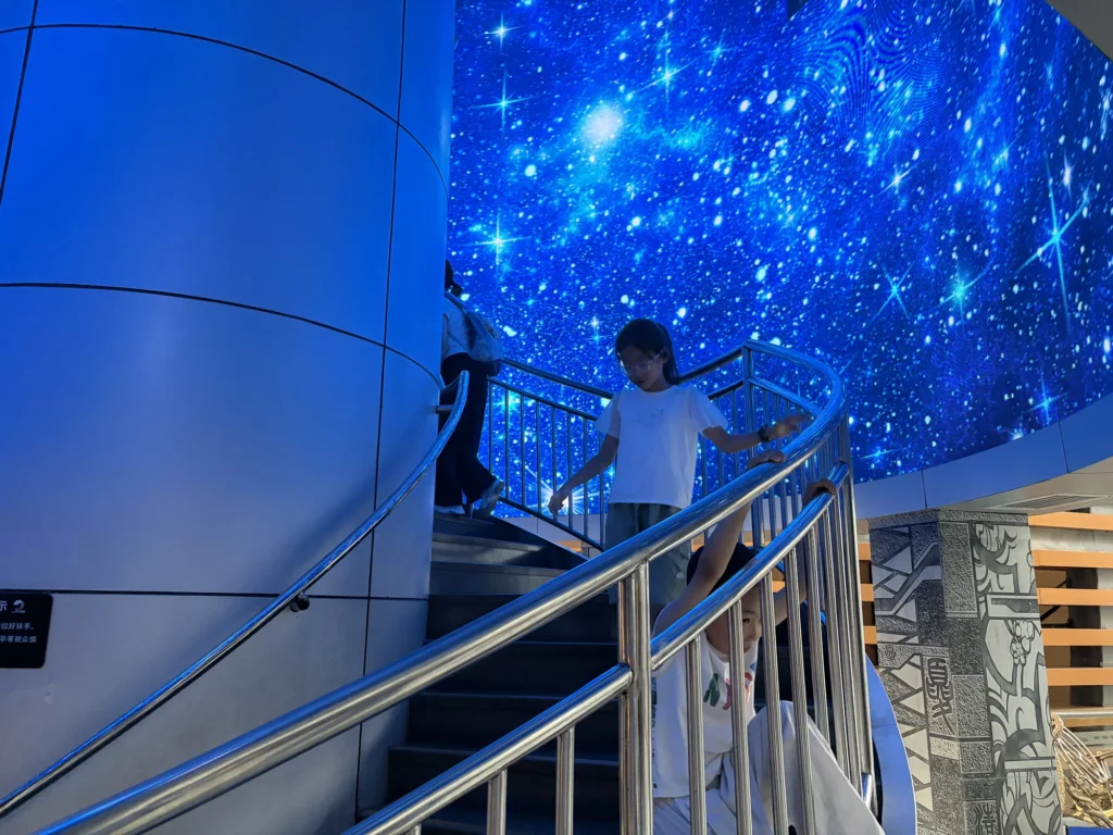 通往模擬太空站的旋轉星空樓梯 Space-Themed Stairway with Rotating Visuals Leading to the Space Station Simulator